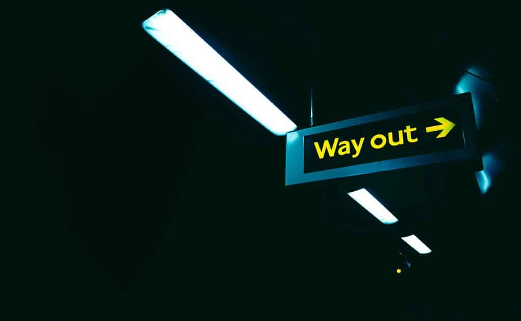 An illuminated exit sign reading Way Out above a doorway